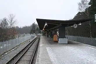 Het perron met de blik richting noorden, rechts de bomen van de Skogskyrkogården