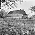 Grote boerderij onder rieten schilddak, de langsdakvlakken gedeeltelijk met pannen gedekt. Voorgevel bestaande uit deur met 6-ruits bovenlicht, een 16 ruits raam en twee 9-ruits ramen, alle met luiken behangen