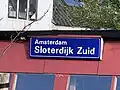 Het stationsbord op een tuinschuurtje op de plaats waar voorheen zich het perron bevond. April 2021