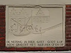 Tekst gevelsteen: De nering is hier goet Goft lof / Men draecht het bier hier op en op (mei 2014); op de achtergrond het veerhuis