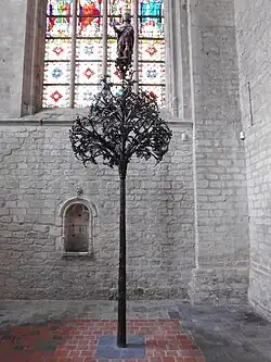 Smeedijzeren boom met een beeld van Sint-Gummarus bovenaan. De boom staat heden ten dage in de Sint Gummaruskerk