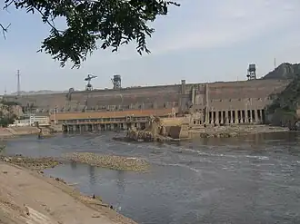 De dam met links de gebouwen van de centrale en rechts de spuisluizen voor de afvoer van het sediment