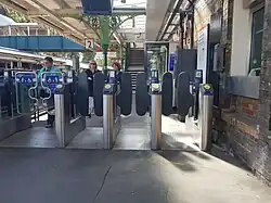 De toegangspoortjes en op de achtergrond de trappen en loopbrug naar het oostelijke perron.