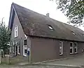 Boerderij, onder rieten zadeldak met aan de voorzijde geschulpte houten daklijst
