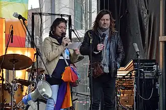 Woordvoerder Ludo De Brabander (rechts) op podium bij een vredesbetoging in 2023