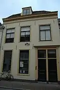 Pand met gepleisterde lijstgevel, met gevelsteen "Dit huis heet Scherpenburgh"