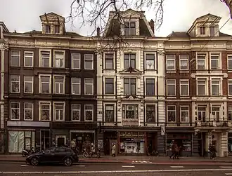 Man met regenjas wandelt voorbij. December 2015