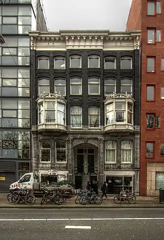 Het gebouw, ingeklemd tussen de veel grotere buren. December 2015.