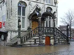 Stadhuis Gouda met beelden van zakkendragers onder het bordes.