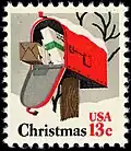 Een brievenbus met kerstcadeaus en kerstkaarten met kerstwensen op een kerstpostzegel uit Verenigde Staten, 1977