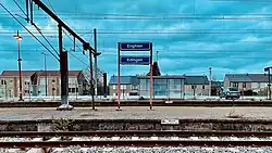 Een plaatsnaambord op een perron