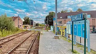Station Schelle. Treinen rijden in België links, dus deze perrons hebben de gunstige positie voorbij de overweg.