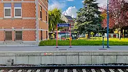 Een plaatsnaambord op een perron