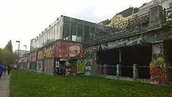 De noordelijke toegang met het typische hek van de Stadtbahn boven de galerij waar de metro doorheen rijdt.