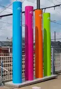 Veelkleurige totempalen, geplaatst in het kader van "het Station"