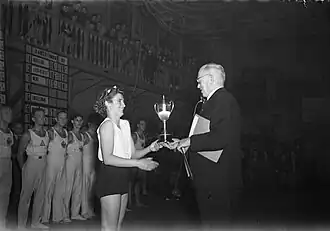 Na de Steenwedstrijd mocht Truida Heil-Bonnet in de Turnhal Amsterdam een beker in ontvangst nemen (24 december 1947)