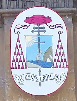 Wapenschild van kardinaal Razafindratandra, met de spreuk Ut omnes unum sint (Opdat allen één zijn). Afbeelding uit de basiliek Santi Silvestro e Martino ai Monti, Rome