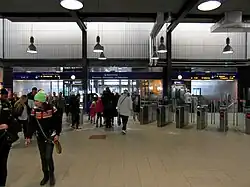 De stationshal met links en rechts van de uitgang de trappen en liften naar de perrons