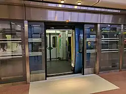 Perrondeur tussen rijtuig en perron.