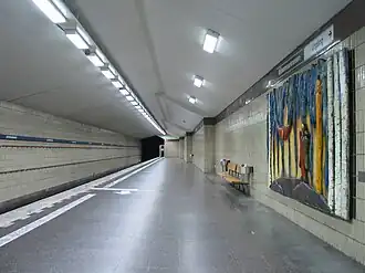 Het perron met een houtreliëf aan de muur