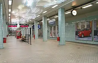 Het perron met het neonkunstwerk aan het plafond