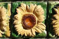 Zonnebloemtegels in buitenmuur