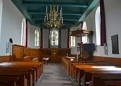 Interieur naar het oosten met kansel, herenbank en koor