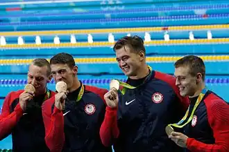 Caeleb Dressel (uiterst links)