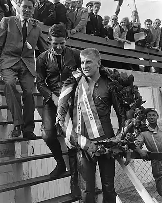 John Hartle, TT van Assen 1963. Achter hem teamgenoot Phil Read en teammanager Geoff Duke.