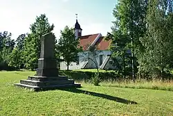 Monument voor de Estische Onafhankelijk-heidsoorlog met op de achtergrond de kerk van Taagepera