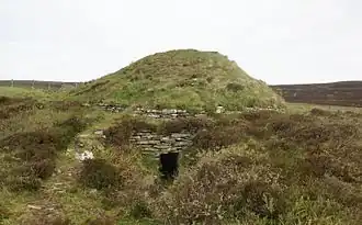 De Taversöe Tuick Chambered Cairn gezien vanaf de zuidzijde met de toegang tot de onderste kamer.