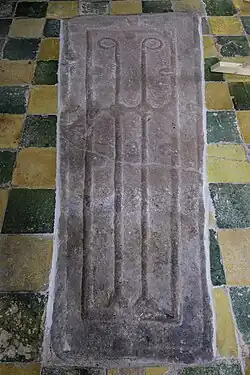 Elfde- of twaalfde-eeuws trapeziumvormig sarcofaagdeksel in de vloer