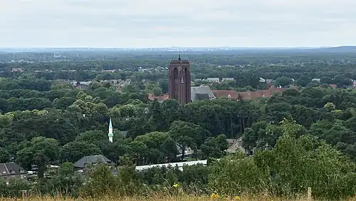 Gezicht op de Maasvallei vanaf het panoramapunt op de lange terril met de mijnkathedraal en de moskee