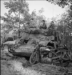 Korporaal P.W. Collins, motorordonnans van het Royal Corps of Signals bij de 11e Pantserdivisie levert een bericht af bij de commandant van een Cromwell tank, 23 oktober 1944.