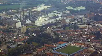 Het stadion in 2010, met rivier Gete (verhuld door groen) en de Tiense Suikerraffinaderij linksachter.