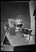 De kerstman met een rendier op een dak bij een schoorsteen, 1938