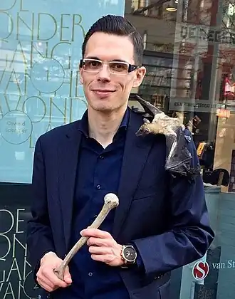 Tjerk Noordraven met vleerhond en mensenbot bij een lezing in Den Haag.