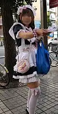 Zogenaamde 'Akihabara maid'; veelal in fantasie 'werksteruniform' uitgedost meisje dat pamfletten voor de lokale handel of activiteiten op straat uitdeelt.