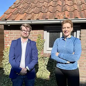 Op de foto staan twee mensen, met aan de linkerzijde de voorzitter van SH-Jong, en aan de rechterzijde Tweede Kamerlid Inge van Dijk