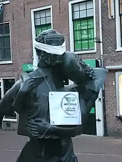 beeld van 2 personen met maskers. Tijdelijk geblinddoekt door klimaatactivisten.