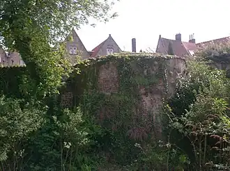 Toren van de eerste stadsomwalling in de tuinmuur van een huis in de Pieter Pourbusstraat, zichtbaar vanuit de Pottenmakersstraat