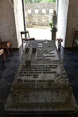 De tombe met menselijke resten van het voormalig kerkhof