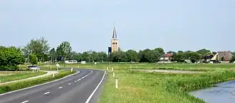 Zicht op Tzummarum. De weg N393 en rechts de Oosterbierumervaart