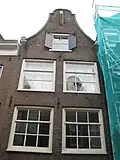 Huis met gevel onder klokvormige top met rollagen