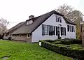 Hoeve met gepleisterd woongedeelte, waarin vensters met ramen uit de eerste helft 19e eeuw. Gaaf bouwlichaam. Grote houten schuur achter de boerderij