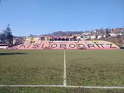 Onoverdekte tribune aan de lange zijde van het veld