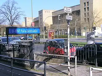 Toegang tot station Paradestraße, op de achtergrond gebouwen van luchthaven Tempelhof