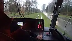 Uitzicht over de schouder van een trambestuurder.