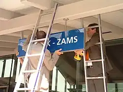 De burgemeesters van Landeck en Zams hangen samen het naambord met de nieuwe naam op