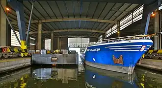 overslag op een kustvaarder, in overdekte loods